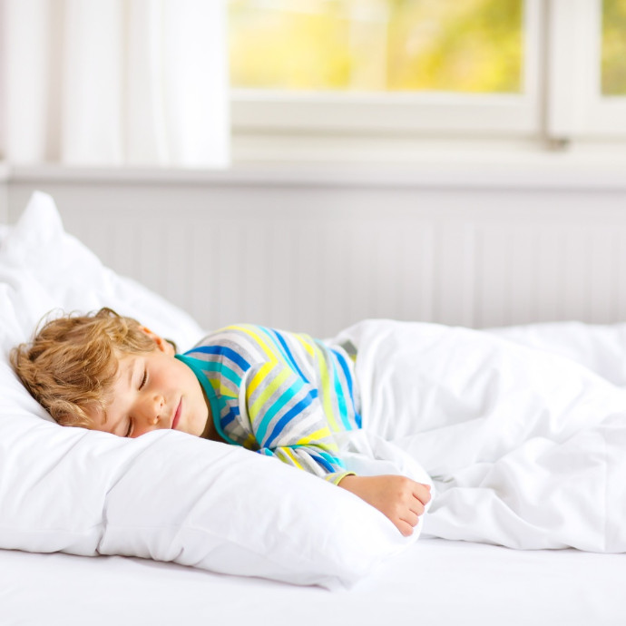 Young boy sleeping peacefully in bed