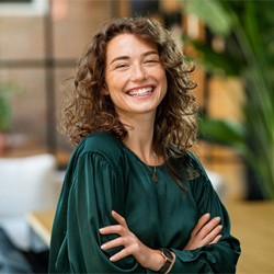 Woman in green shirt smiling outside