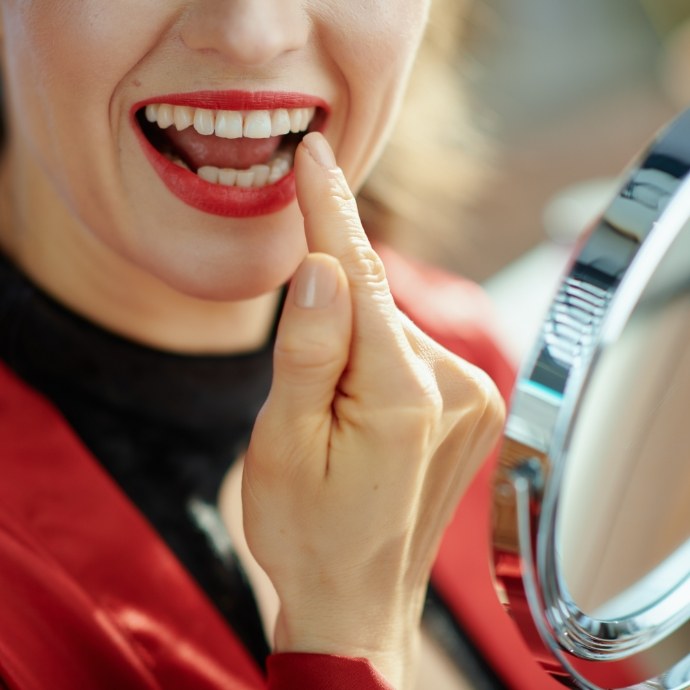 Woman pointing to smile after teeth whitening