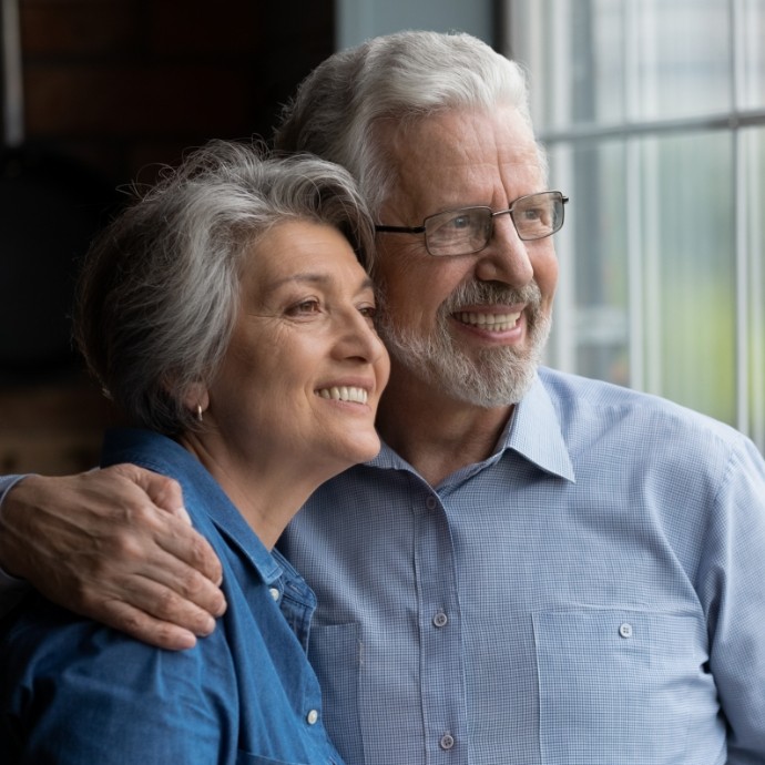 Man and woman smiling and enjoying the benefits of dental implants