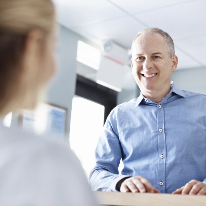 Man discussing dental insurance with dental team member