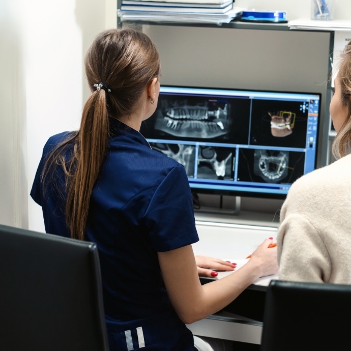 Dental team members looking at panoramic digital x-rays