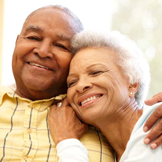 Older couple smiling and hugging at home