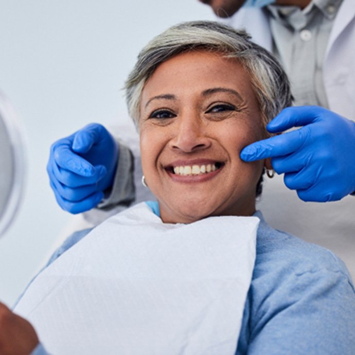 a smiling woman sitting in a dental chair