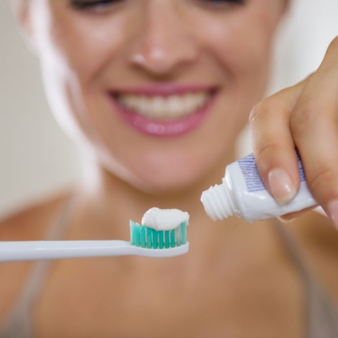 Woman brushing teeth to prevent dental emergencies