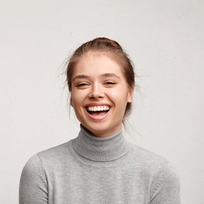 woman smiling against gray background