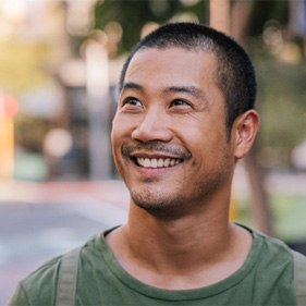 Man in green shirt walking down the street.