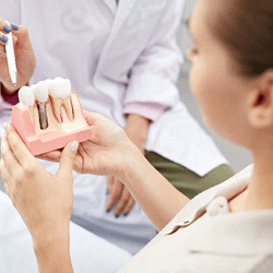 A dentist explaining the benefits of dental implants in Longmont