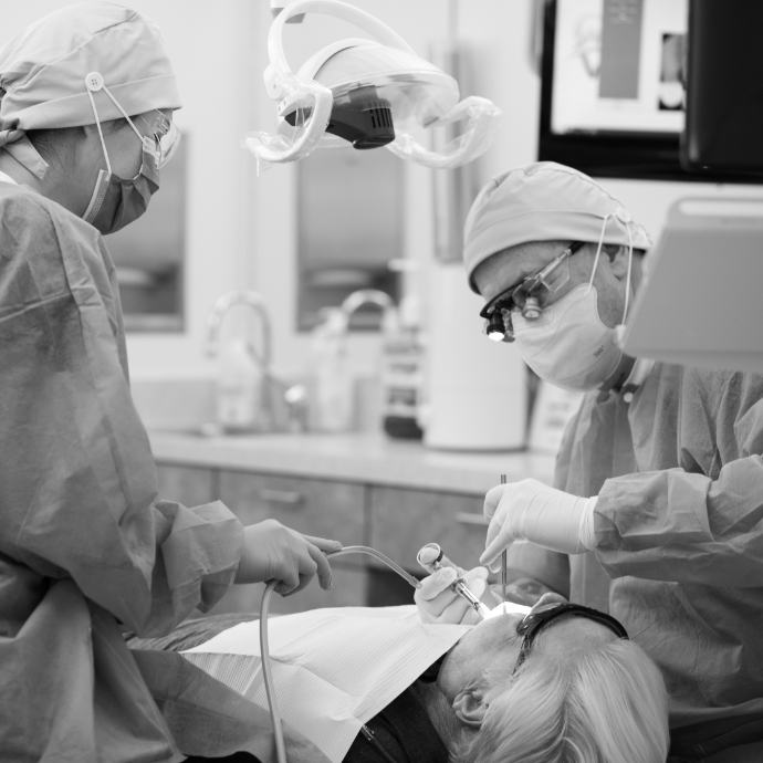 Dentist and team member treating dental patient