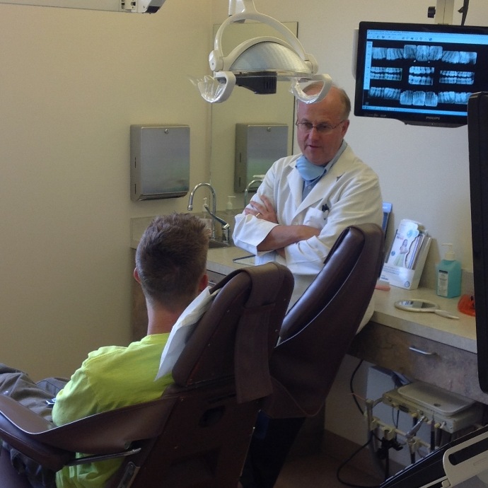 Dentist talking to patient during preventive dentistry checkup and teeth cleaning