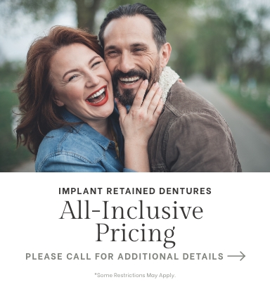 Smiling man and woman with text that reads implant retained dentures all inclusive pricing please call for additional details