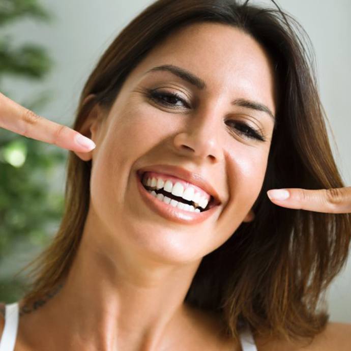 Dentist holding veneer in Longmont with tweezers