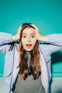 Shocked woman with hands on her head